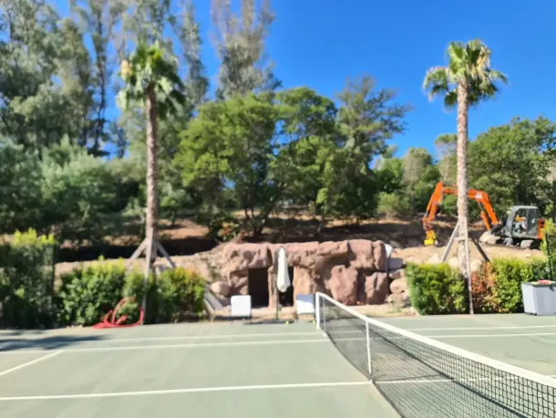 résultat final d'un local technique réalisé en faux rochers artificiel au bord d'un terrain de tennis