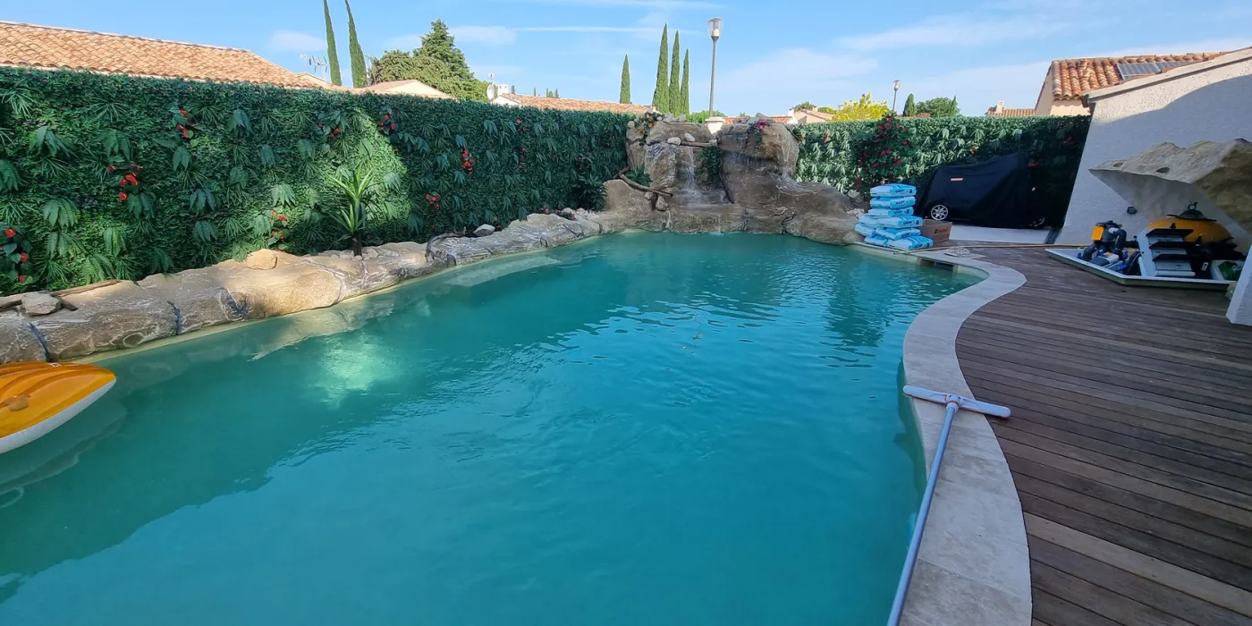 piscince avec faux rochers artificiels et terasse en bois