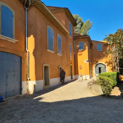 Façade rénovée couleur ocre sur bâtisse ancienne – authenticité et charme préservés