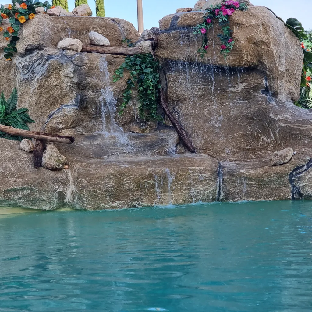 piscine en eau avec rocher artificiel présentant une cascade artificielle autre vue