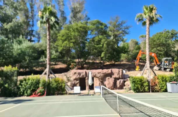 résultat final d'un local technique réalisé en faux rochers artificiel au bord d'un terrain de tennis