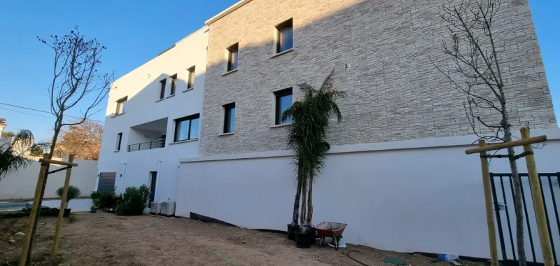 facade blanche neuve sur une résidence d'environ 100m de long