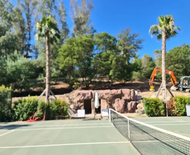résultat final d'un local technique réalisé en faux rochers artificiel au bord d'un terrain de tennis
