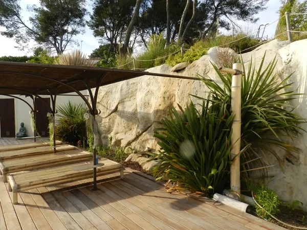 pierre décorative jaunie sur le mur d'un jardin devant une terasse