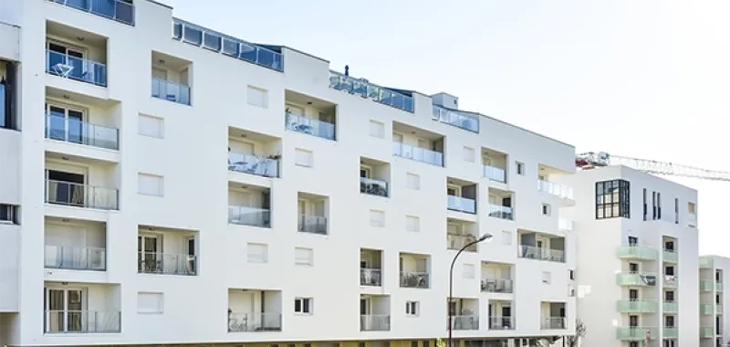 Résidence contemporaine avec façade mixte : enduit blanc épuré et parement pierre élégante
